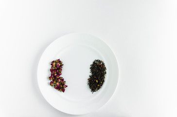 Small buds of red roses and flower tea on a white plate background white