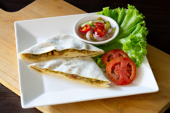 Roti mataba and in white dish on wooden table Muslim food, Halal food and vegetable pickled sauce in cup on wooden chopping board