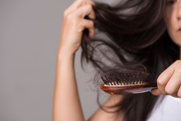 Healthy concept. Woman show her brush with long loss hair and looking at her hair.