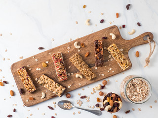 Granola bar with copy space. Set of different granola bars on cutting board over white marble table. Shallow DOF. Top view or flat lay.