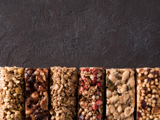 Granola bar with copy space. Set of different granola bars on black background. Shallow DOF. Top...
