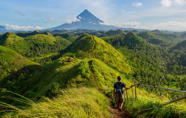 Hiker with backpack looks at the view on the Mayon volcano,Quit in Day Hills area,Philippines