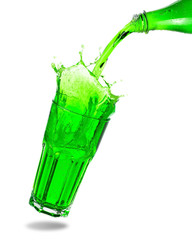 Pouring green soda from bottle into glass with splashing isolated on white background.