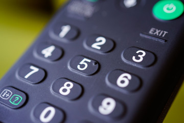 Man holding tv remote commander and number channel