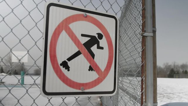 Now roller blading sign on chain link fence