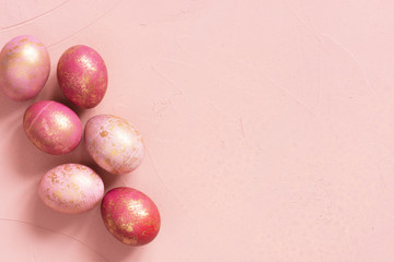 Background with pink Easter eggs with golden spots