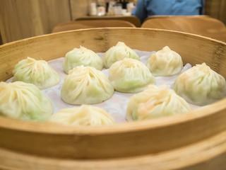 Basket of xiaolongbao (steamed meat bun), famouse asian food. Chinese dumplings on bamboo steamer.