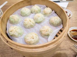 Basket of xiaolongbao (steamed meat bun), famouse asian food. Chinese dumplings on bamboo steamer.