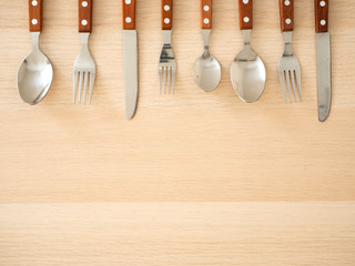 Silver cutlery set on wooden table