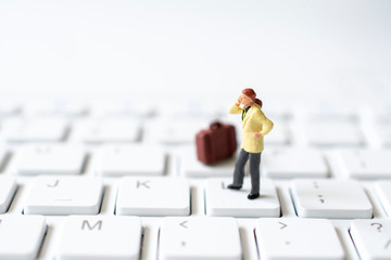 miniature business man on white keyboard , selective focus