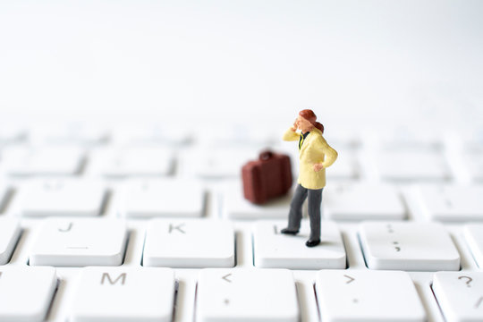 miniature business man on white keyboard , selective focus - Powered by Adobe