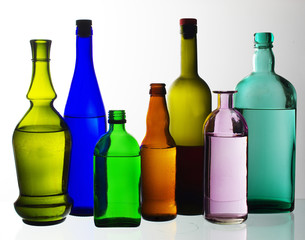 Two glasses of wine and bottles of wine and gin on the light.