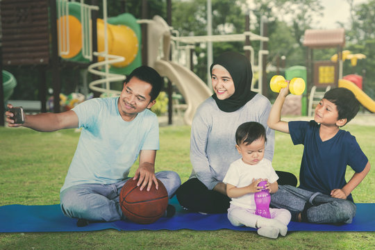 Happy family sitting at the playground