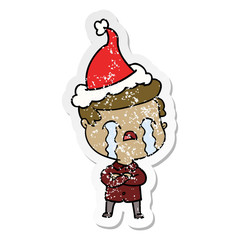 distressed sticker cartoon of a man crying wearing santa hat