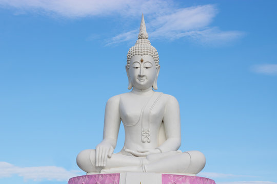 White Buddha statue with blue sky on background.