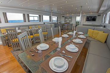 Interior of large salon dining area of luxury motor yacht