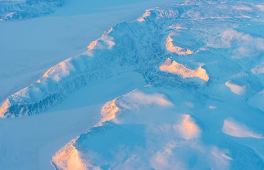 Frozen ocean or sea bay in the snowy arctic climate mountains. Aerial view over a cold winter in...