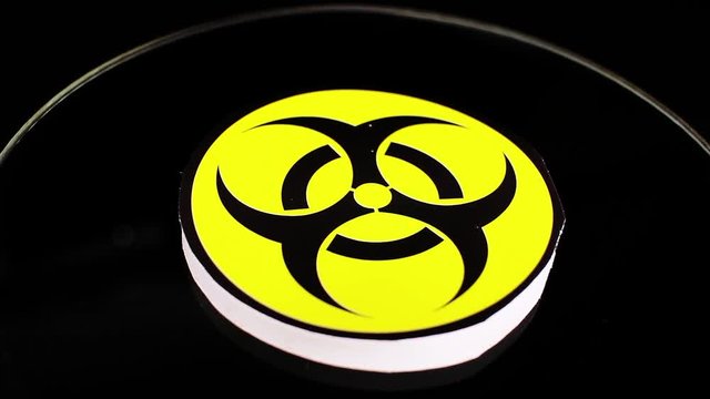 Biohazard sign closeup texture video on rolling rotating looping plate