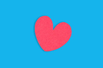 One red paper heart in center of blue table. Top view. Valentines Day concept
