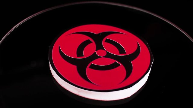 Biohazard sign closeup texture video on rolling rotating looping plate