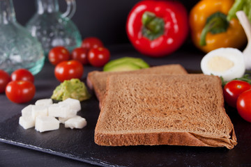 Sliced Toast Bread on black plate with vegetables