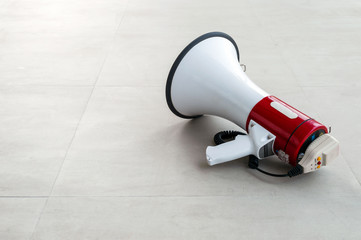 old megaphone on cement floor with soft-focus and over light in the background
