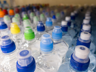 Lid plastic water bottle in the market. multi-colored plastic bottle caps	