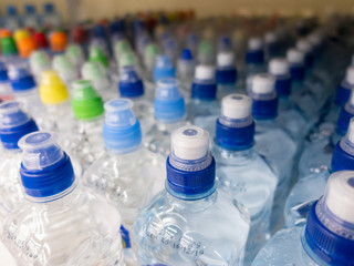 Lid plastic water bottle in the market. multi-colored plastic bottle caps	