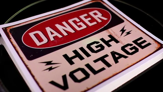 High voltage sign closeup texture video on rolling rotating looping plate
