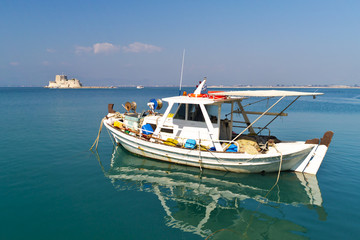 Obraz premium Boat in Nafplio Greece, with mpourtzi castle in background. A bright sunny day.