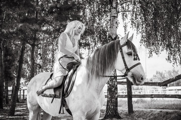 Woman with a white horse in a farm. Concept of animals and human. Spring - summer season, hobby...