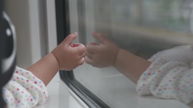 Little baby Traveling by Train. A One Years old Pointing her hand to Outside View, Sitting Near Wide Glass Window. Slow motion