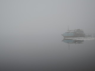 Old rusty ship in fog in spring