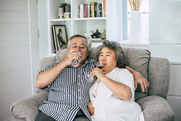 Happy Elderly woman and her husband drinking wine and happiness