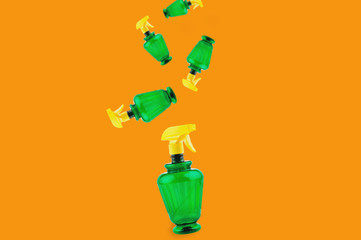Falling plastic sprayers on orange background