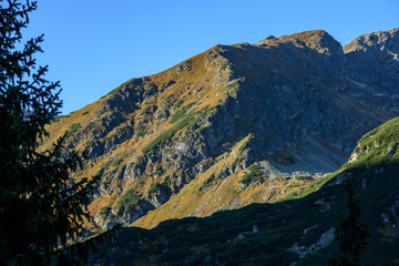 Tatra mountain peaks with tourist hiking trails in sunny summer day