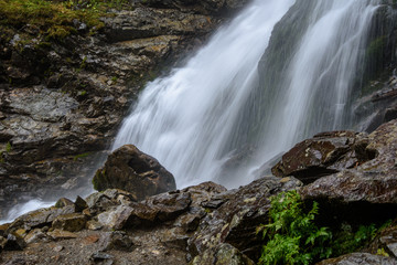 fast mountain rocky river in forest with waterfall