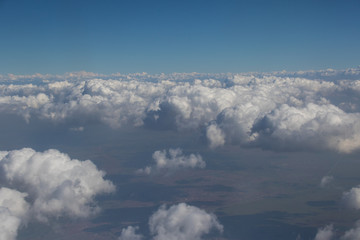 Fototapeta na wymiar View from an aircraft window travelling high above the clouds image for background use with copy space in landscape format