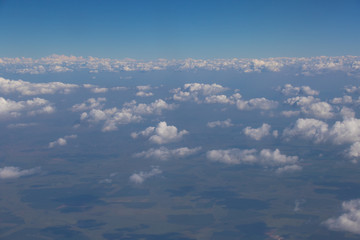 View from an aircraft window travelling high above the clouds image for background use with copy space in landscape format