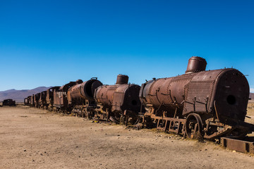 Fototapeta premium Rusting steam trains and carriages slowly rot away at the train graveyard just outside of Uyuni, Bolivia