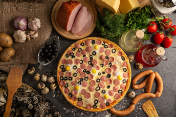 Pizza with sausages, boiled pork and quail eggs.
