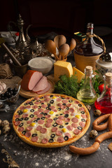 Pizza with sausages, boiled pork and quail eggs.