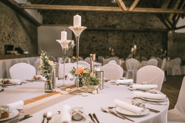 Hochzeitslocation gedeckter Tisch mit Blumen und Dekoration