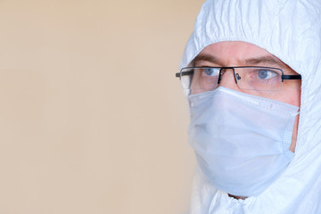 Lab technician, medic. On the face of a protective mask. Glasses. Protective suit.