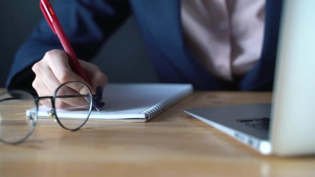 The businessman girl is preparing to write down important information in a notebook