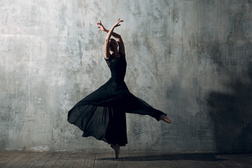 Ballerina female. Young beautiful woman ballet dancer, dressed in professional outfit, pointe shoes and black tutu.