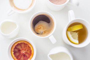 Several different hot drinks on the white table - coffee shop menu