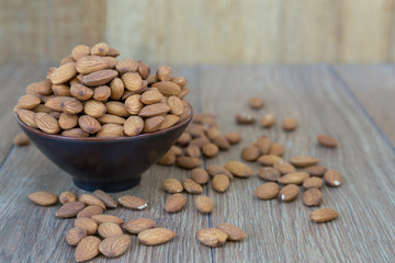 Almond nut on wood background.