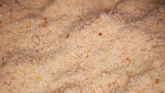 Bread crumbs closeup texture video on rolling rotating looping plate