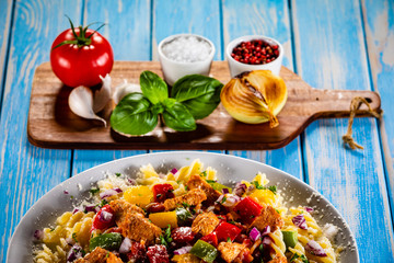 Pasta with vegetables on wooden background